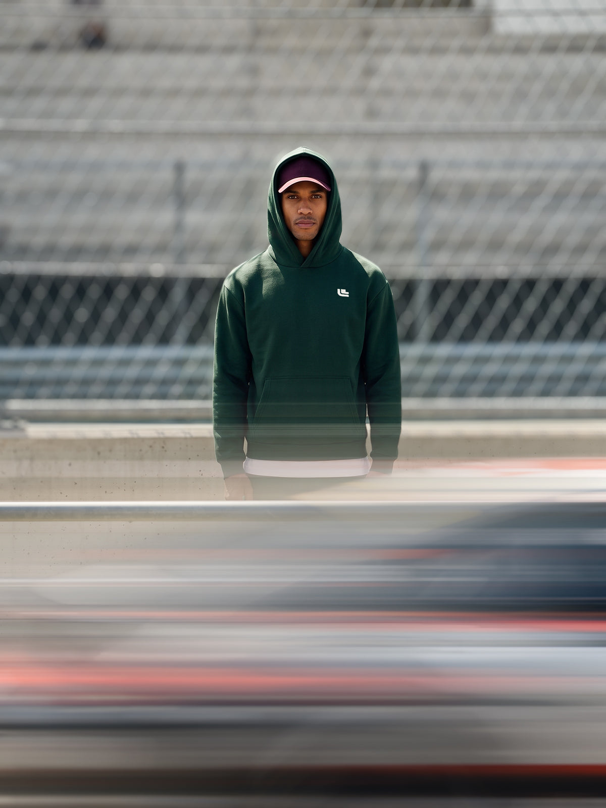 Modell trägt den Driving the Limit Hoodie in Dunkelgrün von vorne mit kleinem Brustlogo